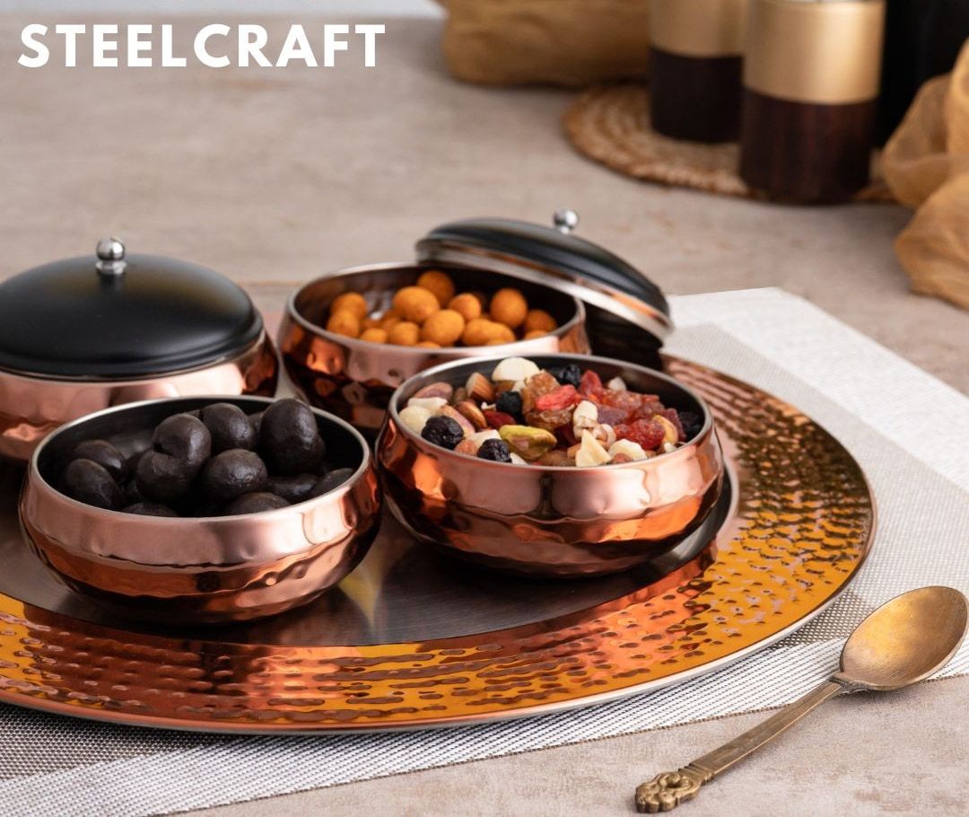 Hammered-copper bowls of dry fruit on a copper tray
