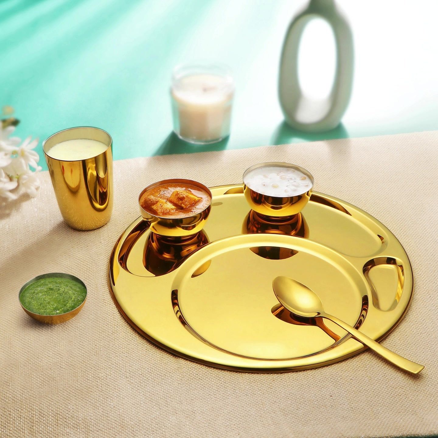 A gold-PVD Steelcraft thali set on linen