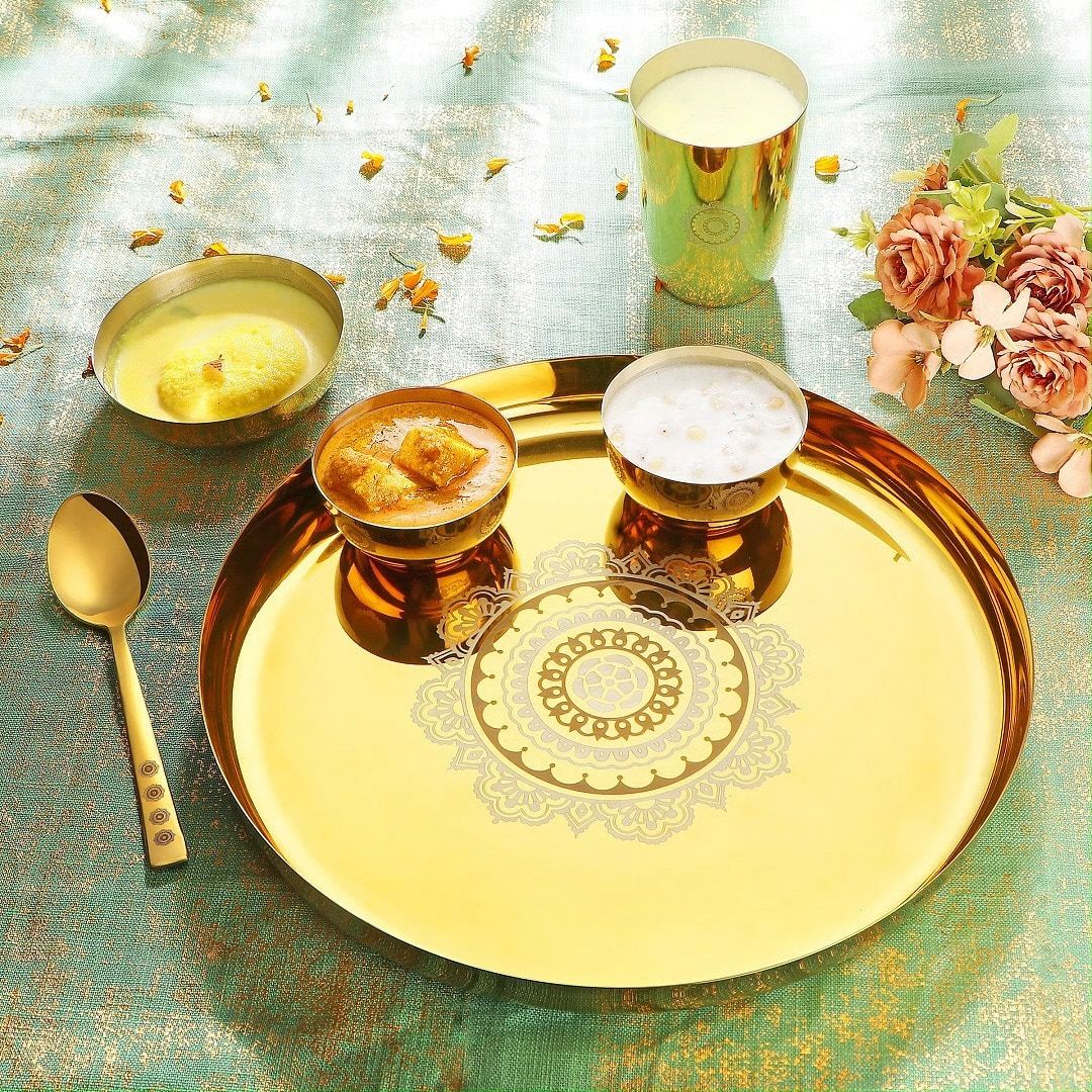 A gold-PVD Steelcraft thali with paneer and kheer on green silk