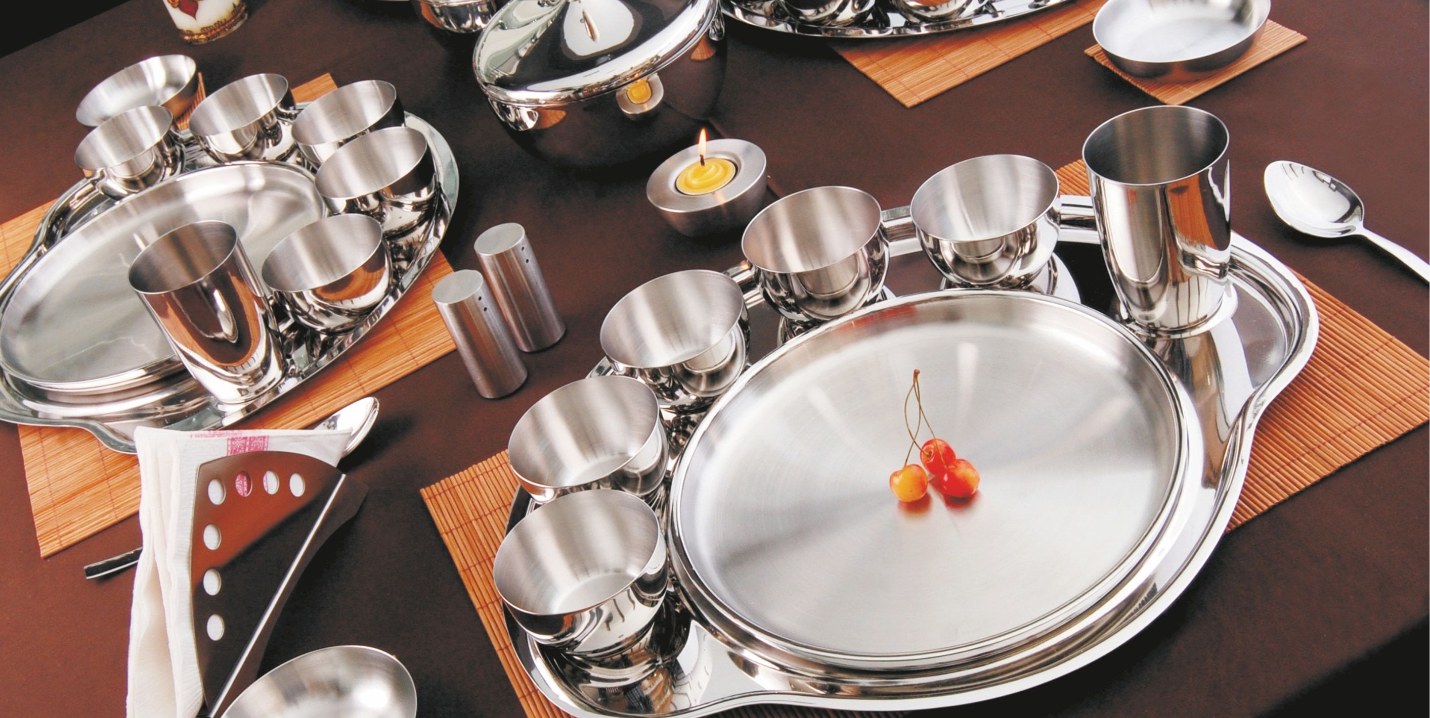 A Steelcraft thali set laid for dinner on a dark table