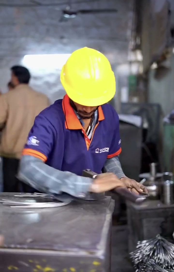 A worker at the press during bucket manufacturing